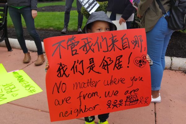 No matter where you are from you are our neighbor boy with protest sign