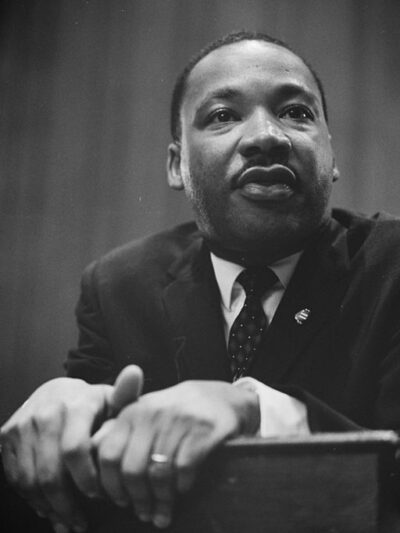 1964 photo of Martin Luther King Jr. leaning on a lectern