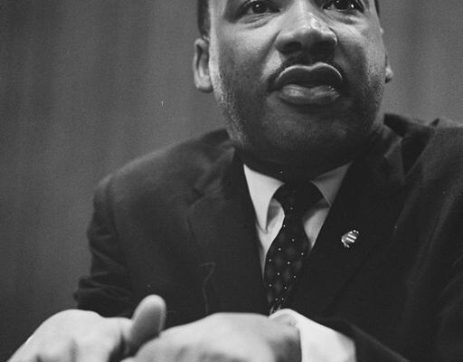 1964 photo of Martin Luther King Jr. leaning on a lectern