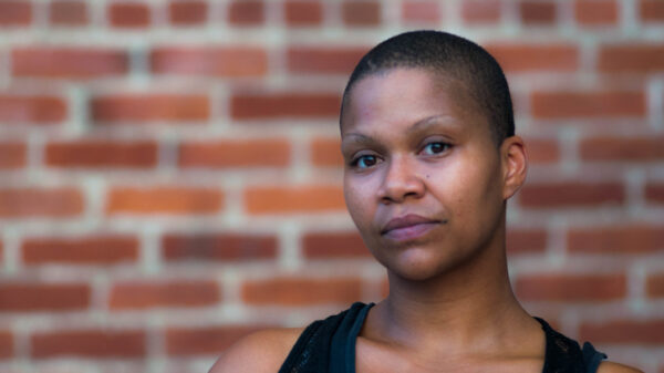 Mary Holmes standing in front of a brick wall