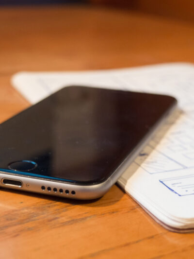 iPhone sitting on open journal on wooden table