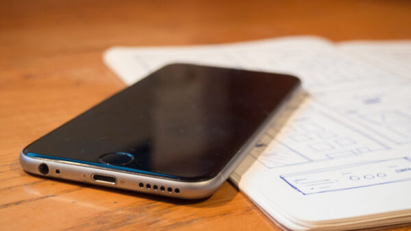 iPhone sitting on open journal on wooden table