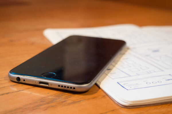 iPhone sitting on open journal on wooden table