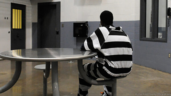 Incarcerated juvenile inmate sits at table