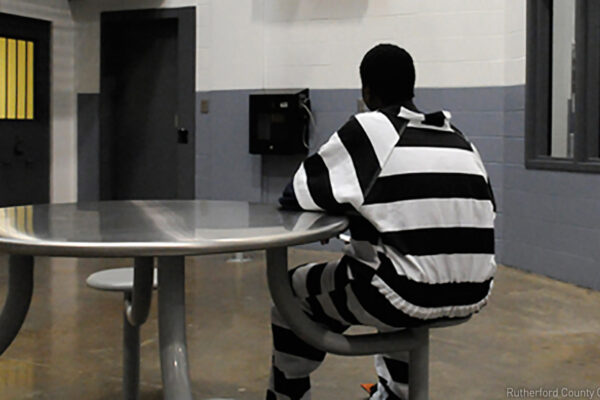 Incarcerated juvenile inmate sits at table