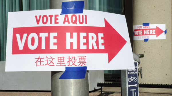 Photo of "Vote Here" sign on pole