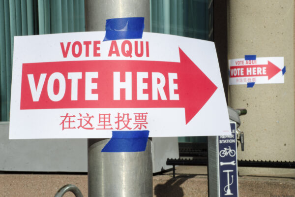 Photo of "Vote Here" sign on pole