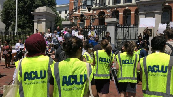Volunteers wearing bright ACLU vests in front of the Massachusetts State House