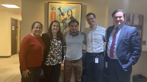 Julio Ramirez stands with members of his legal team in the ACLU of Massachusetts office