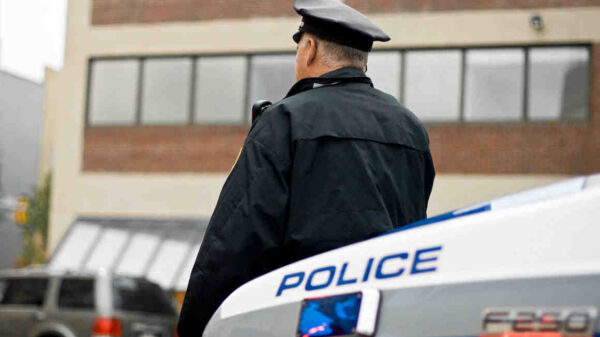 Police officer leaning against police car