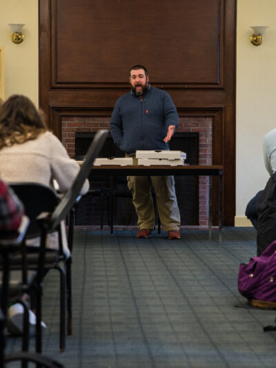 Volunteers sit in rows as ACLU staffer leads training in front