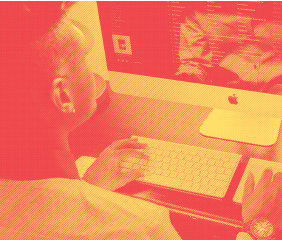 Over the shoulder look at person typing on desktop Mac