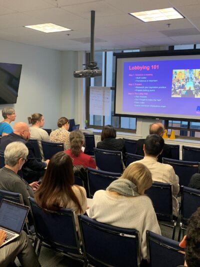 Volunteers watch ACLU staffer Olivia Santoro give a Lobbying 101 presentation