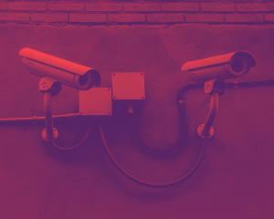 Mounted surveillance cameras against a cement wall