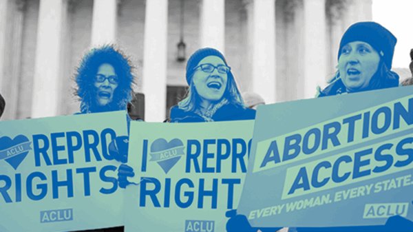 Women holding rally signs for abortion access
