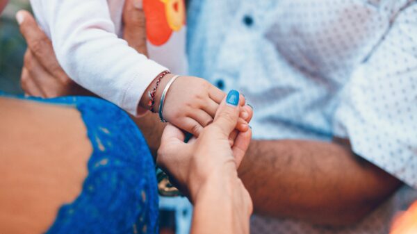 small child and adult holding hands