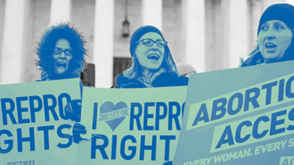 Three individuals standing face forward holding protest sign that read "Repro Rights" "Abortion Access" and "I Heart Repro Rights"