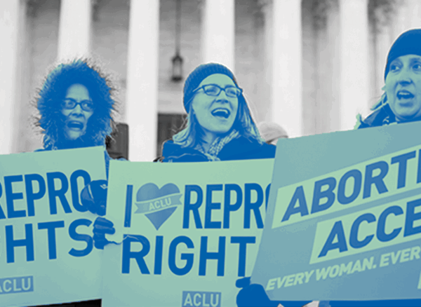 Three individuals standing face forward holding protest sign that read "Repro Rights" "Abortion Access" and "I Heart Repro Rights"