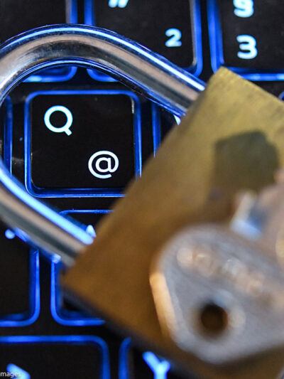 A lock and key on top of a computer keyboard.