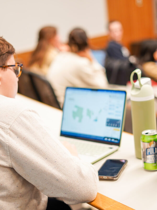 Student at desk looking at computer in a class