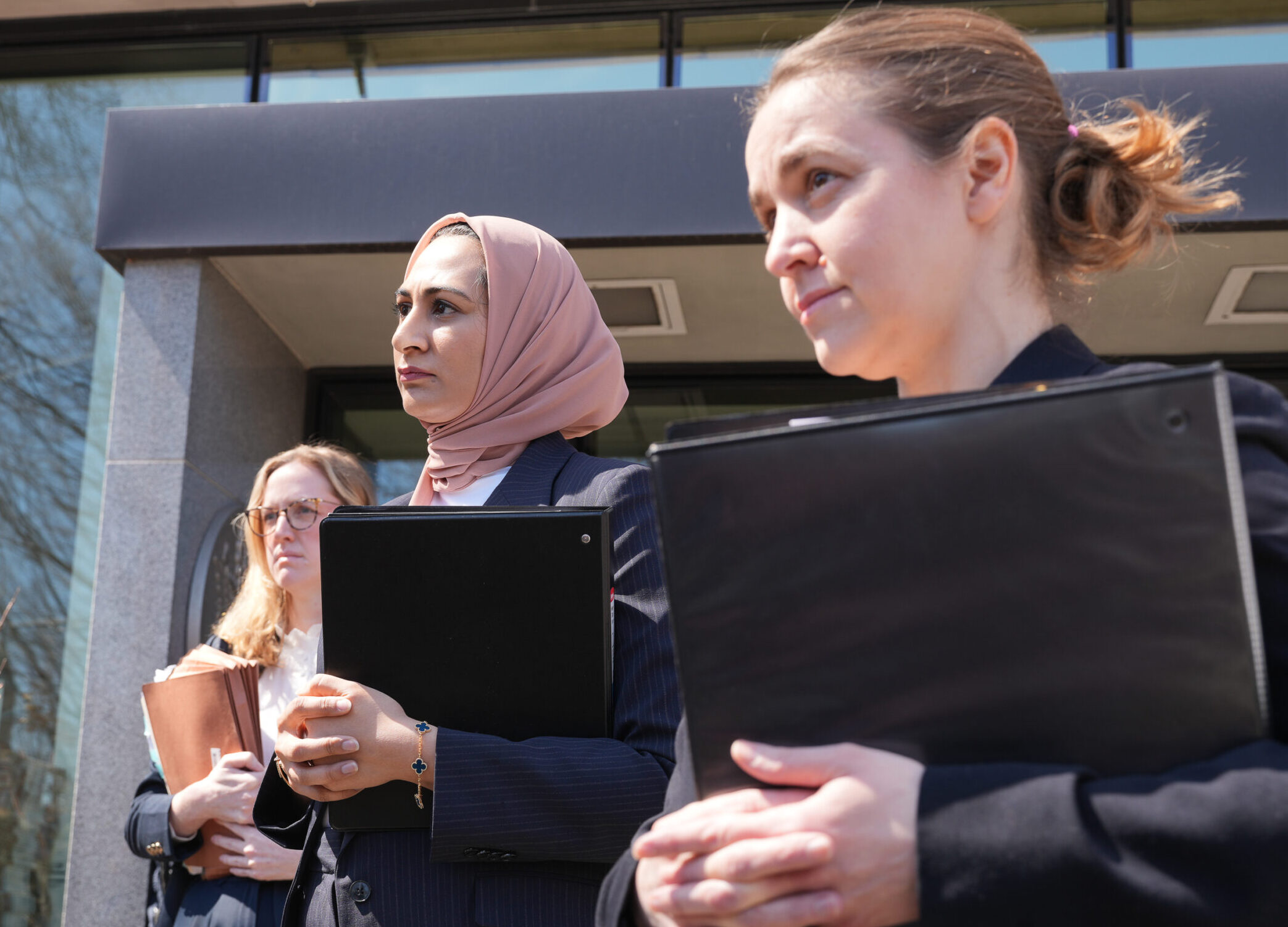 Noor Zafar is a Senior Staff Attorney, Rachel Davidson, Staff Attorney, and Adriana Lafaille, Managing Attorney stand outside federal court in Burlington, Vermont
