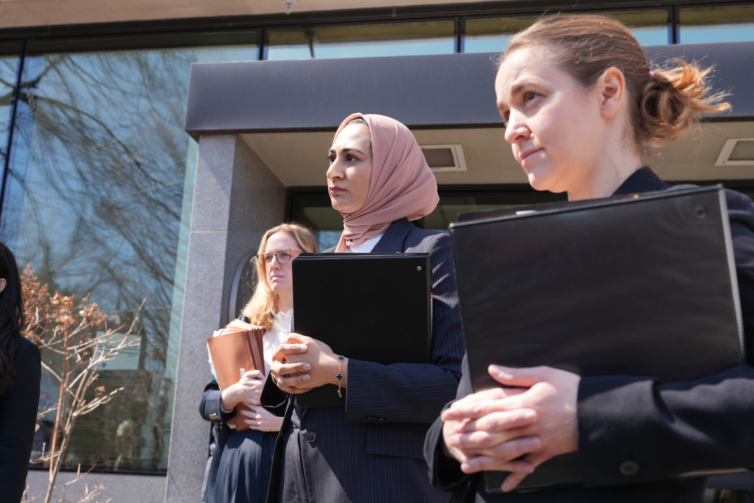 Noor Zafar is a Senior Staff Attorney, Rachel Davidson, Staff Attorney, and Adriana Lafaille, Managing Attorney stand outside federal court in Burlington, Vermont