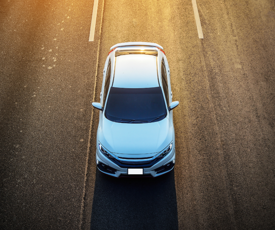 White Vehicle driving into foreground of image.