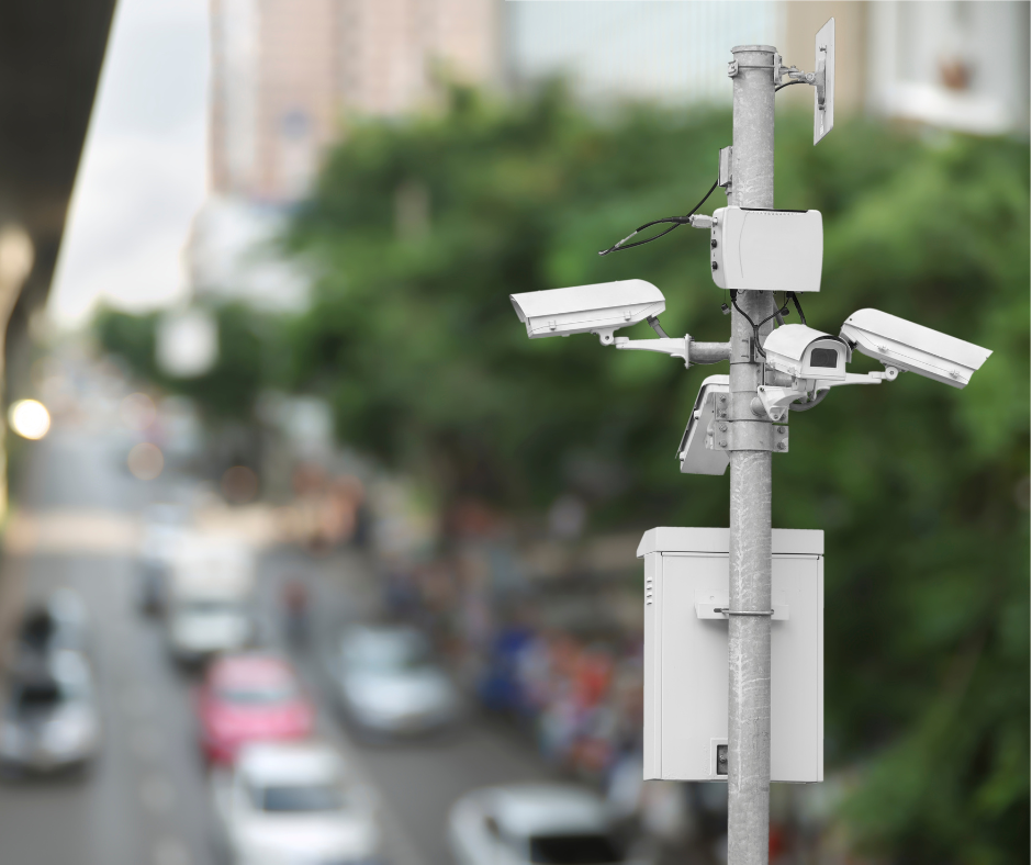 Street camera viewing cars on a highway in daylight.