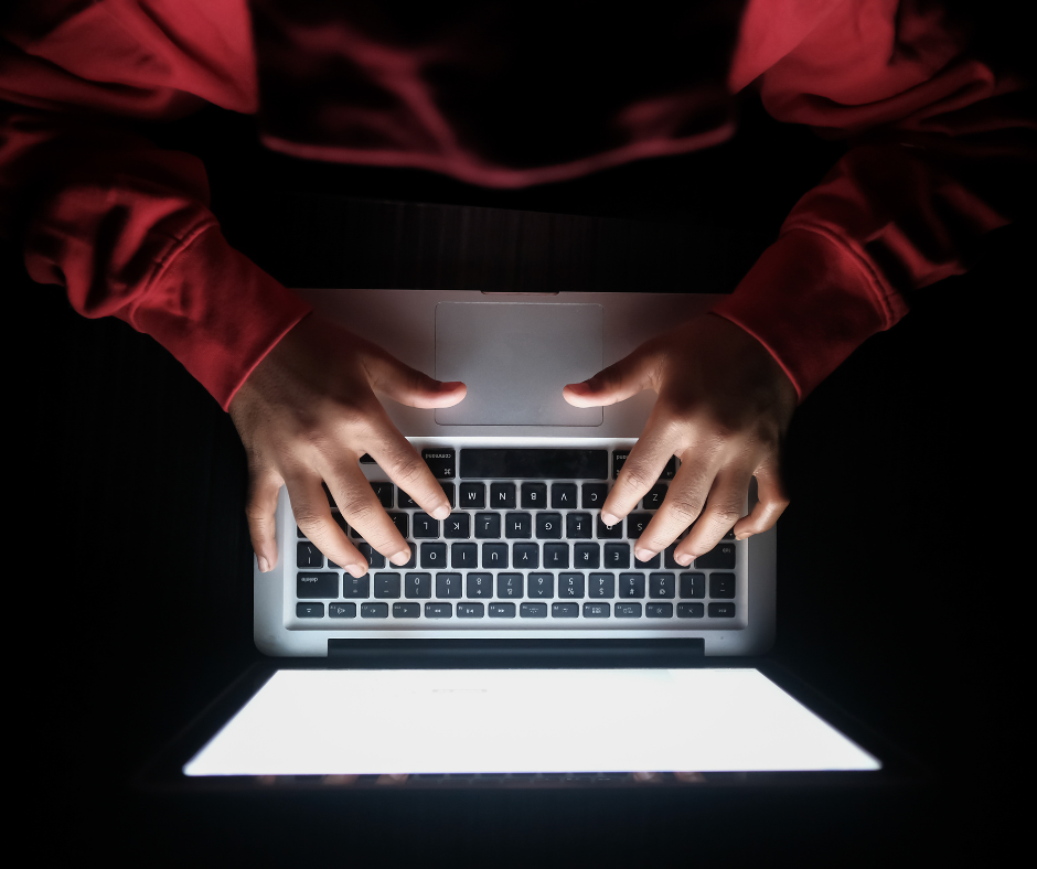 Laptop viewed from the top vertically and individually in a red sweatshirt is typing.