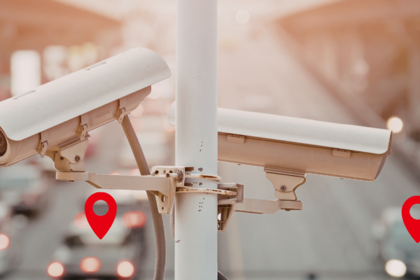 Automatic License plate readers above a highway in daylight. Location pins demonstrate tracking of vehicles in the background.