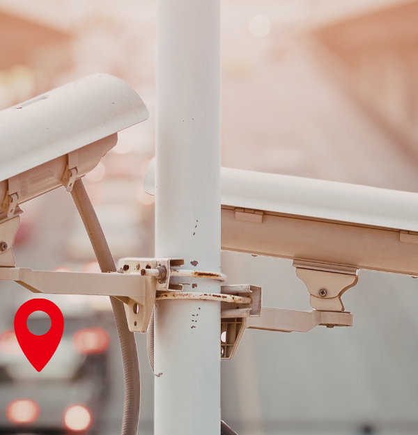 Automatic License plate readers above a highway in daylight. Location pins demonstrate tracking of vehicles in the background.
