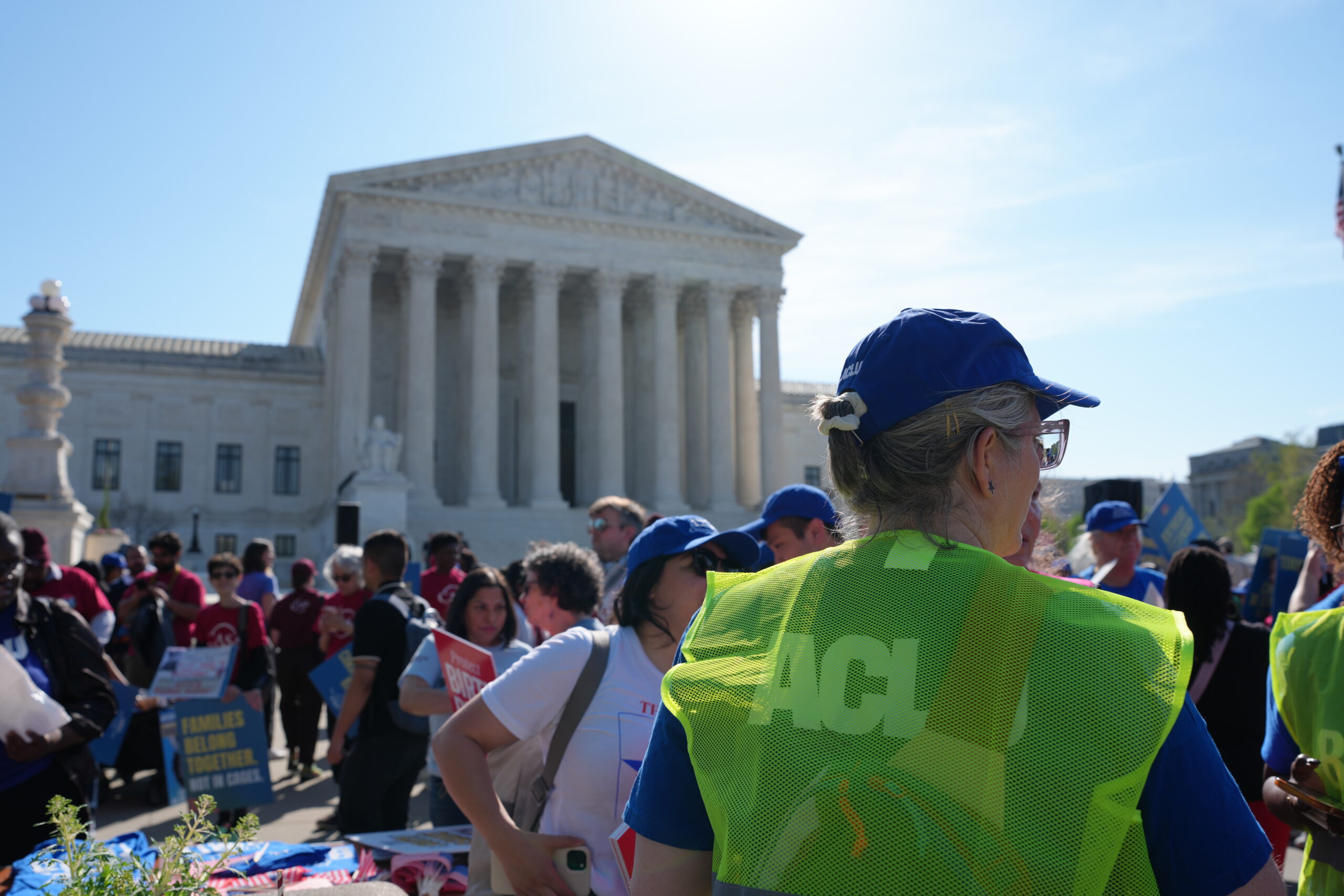 Supreme Court of the United States with rally happening outside. A crowd of people is stood outside the court.
