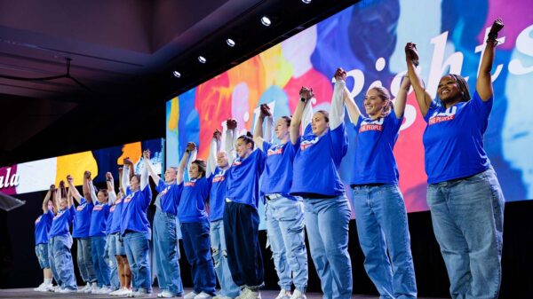 ACLU Members celebrate with raised connected hands on a stage at the Bill of Rights Gala in 2025