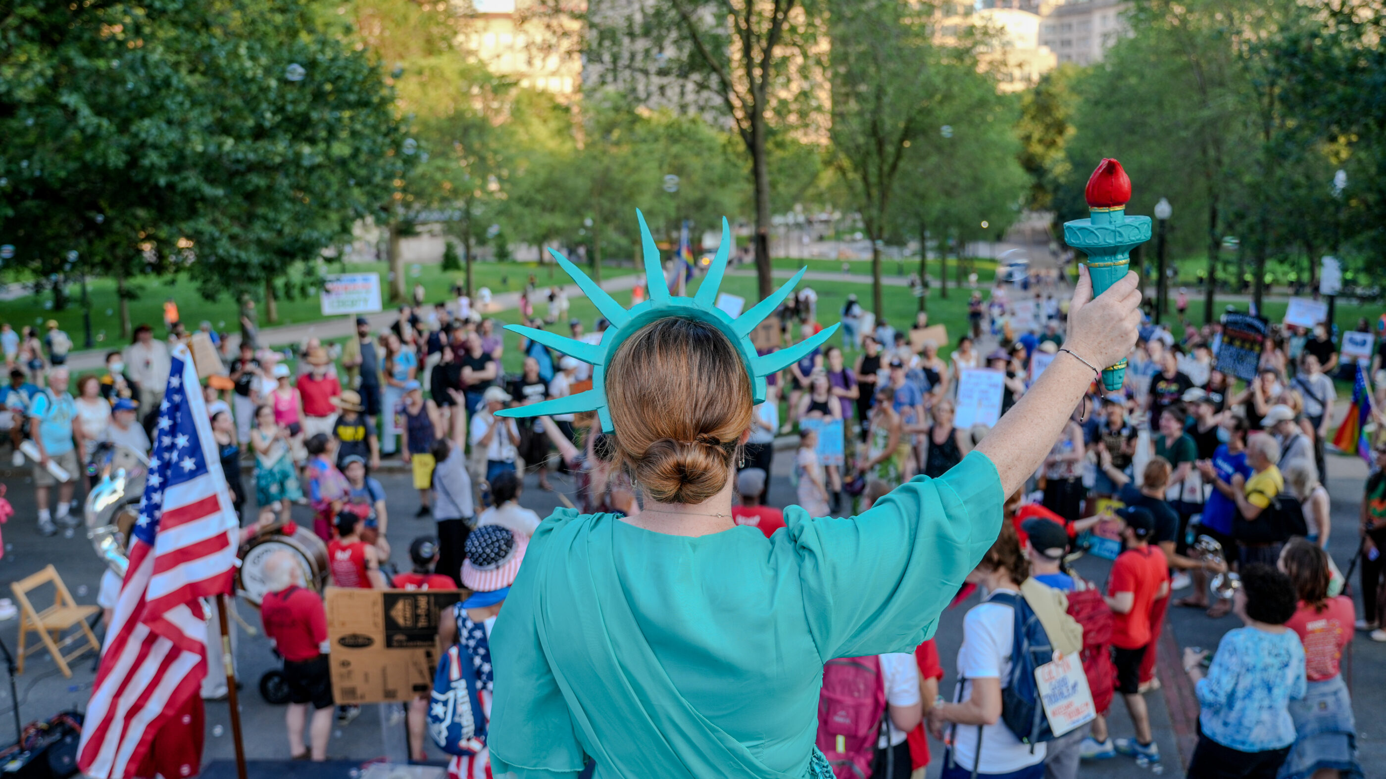 Person dressed at Lady Liberty facing the Boston Common from the Statehouse steps.