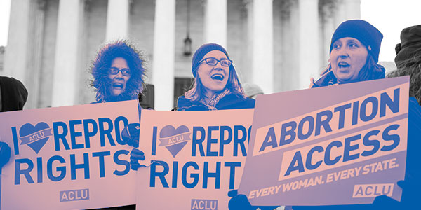 Women holding rally signs for abortion access