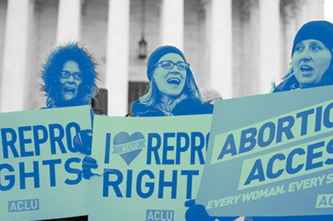 Three individuals standing face forward holding protest sign that read "Repro Rights" "Abortion Access" and "I Heart Repro Rights"