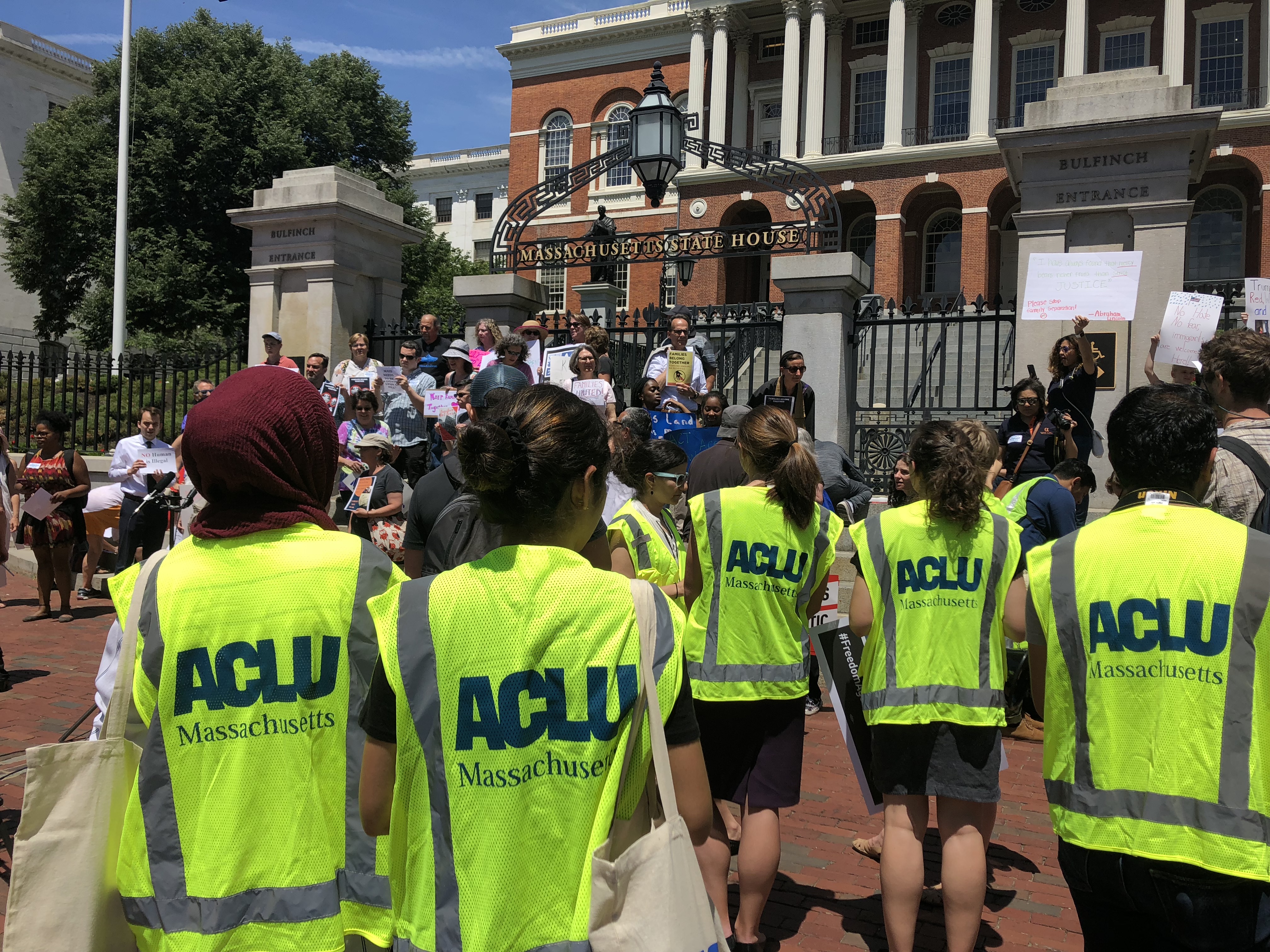 Volunteers wearing bright ACLU vests in front of the Massachusetts State House