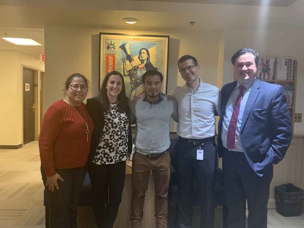 Julio Ramirez stands with members of his legal team in the ACLU of Massachusetts office