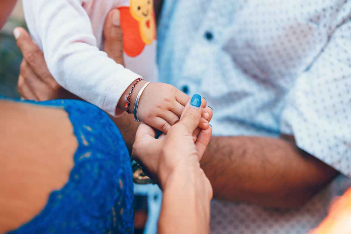 small child and adult holding hands