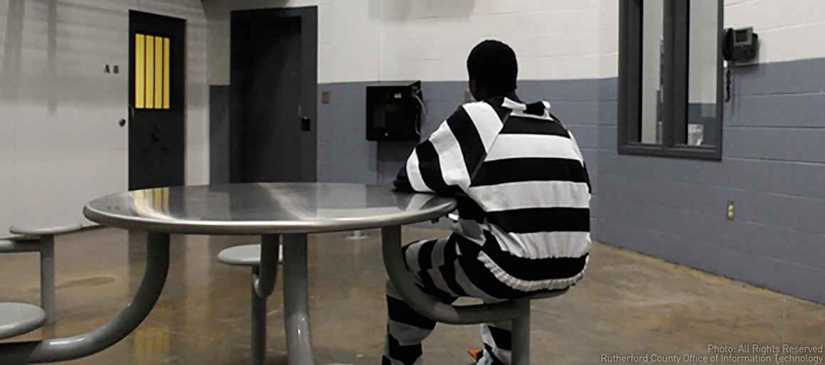 Incarcerated juvenile inmate sits at table