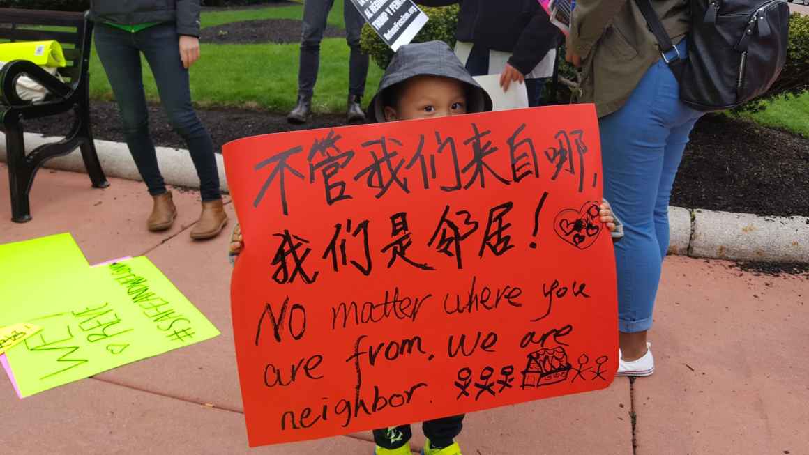 No matter where you are from you are our neighbor boy with protest sign