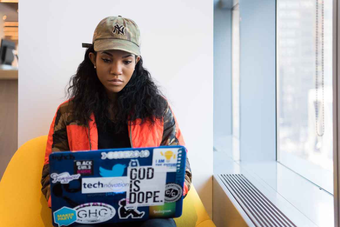 Woman sits typing on her laptop