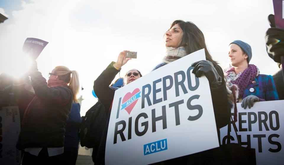 Woman holds "I heart repro rights" sign