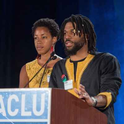 Addis and Christiaan Summerhill speak at podium with ACLU sign