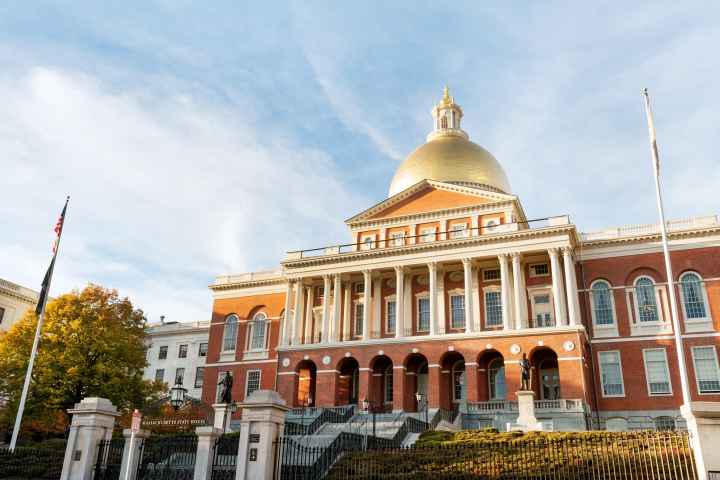 Photo of the outside of the Massachusetts State House in the daylight. 