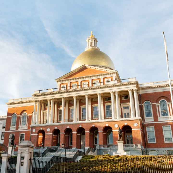 Photo of the outside of the Massachusetts State House in the daylight. 