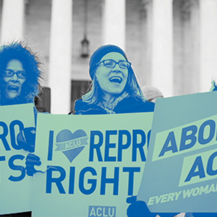 Women holding rally signs for abortion access