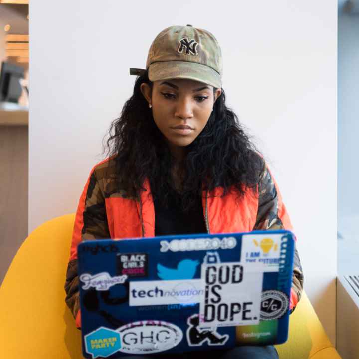 Woman sits typing on her laptop