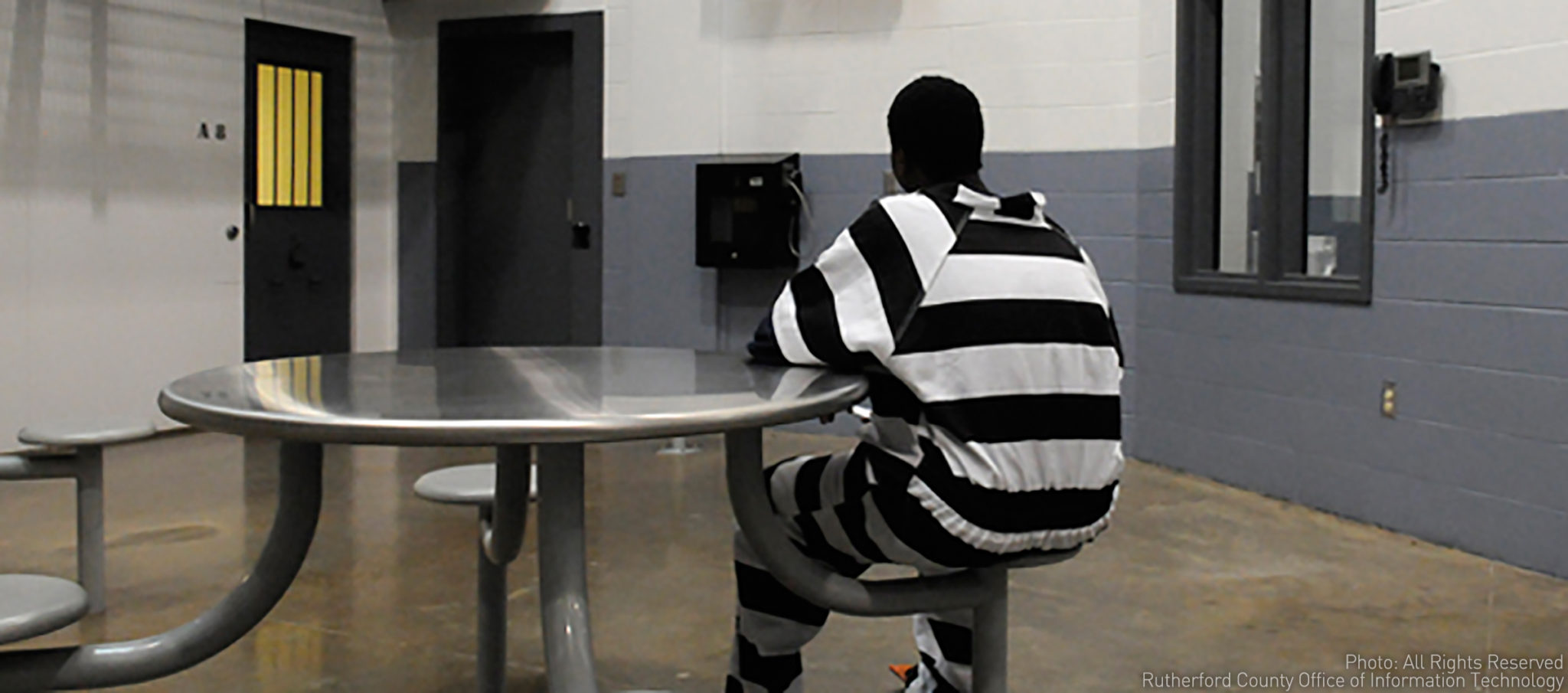 Incarcerated juvenile inmate sits at table 
